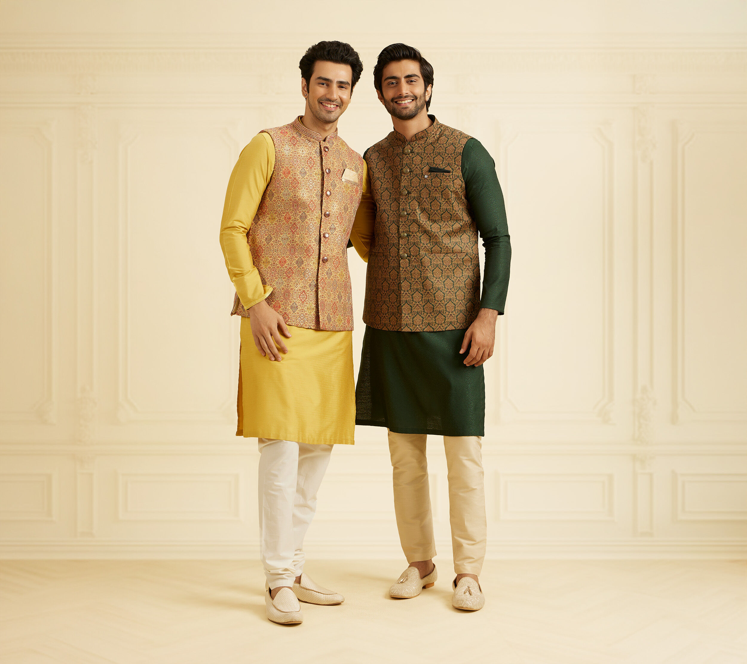 Two men wearing patterned Nehru jackets with kurta pajamas, showcasing festive Indian ethnic fashion for weddings and celebrations.